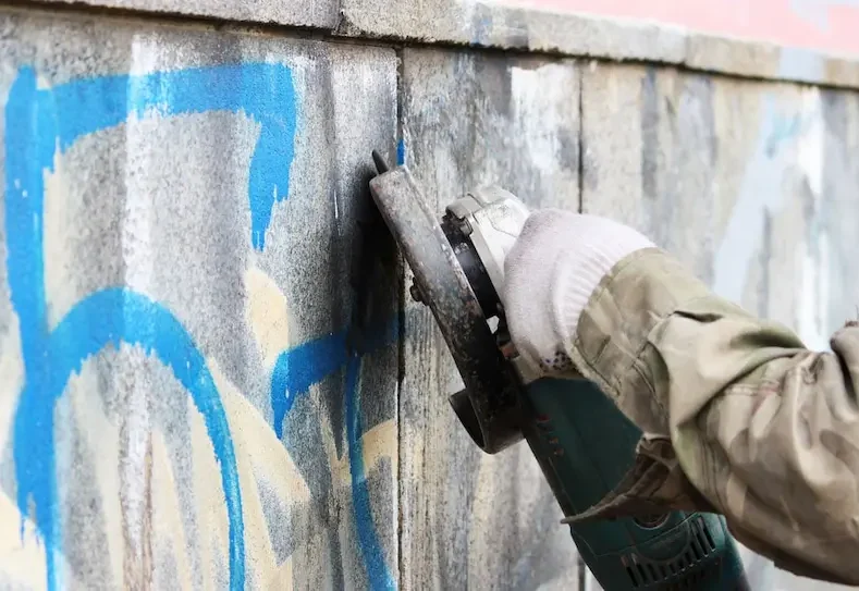 Removing Graffiti On A Concrete Wall Using Professional Cleaning Equipment — Hire Pro In Mudgeeraba, QLD