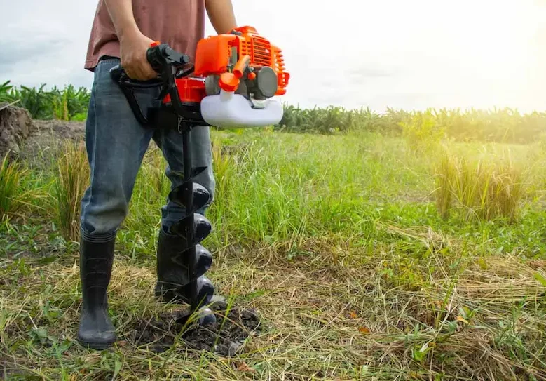 Hand-Held Soil Hole Drilling Machine In Use — Hire Pro In Mudgeeraba, QLD